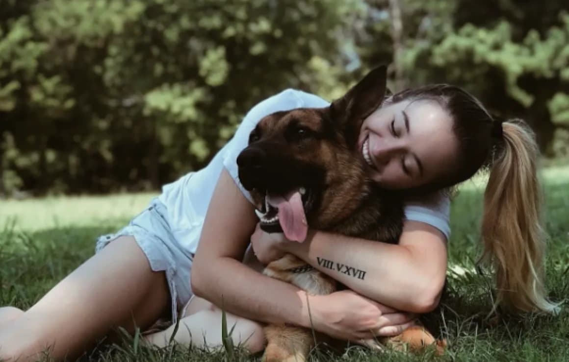 HellaK9s client smiling with her trained German Shepherd